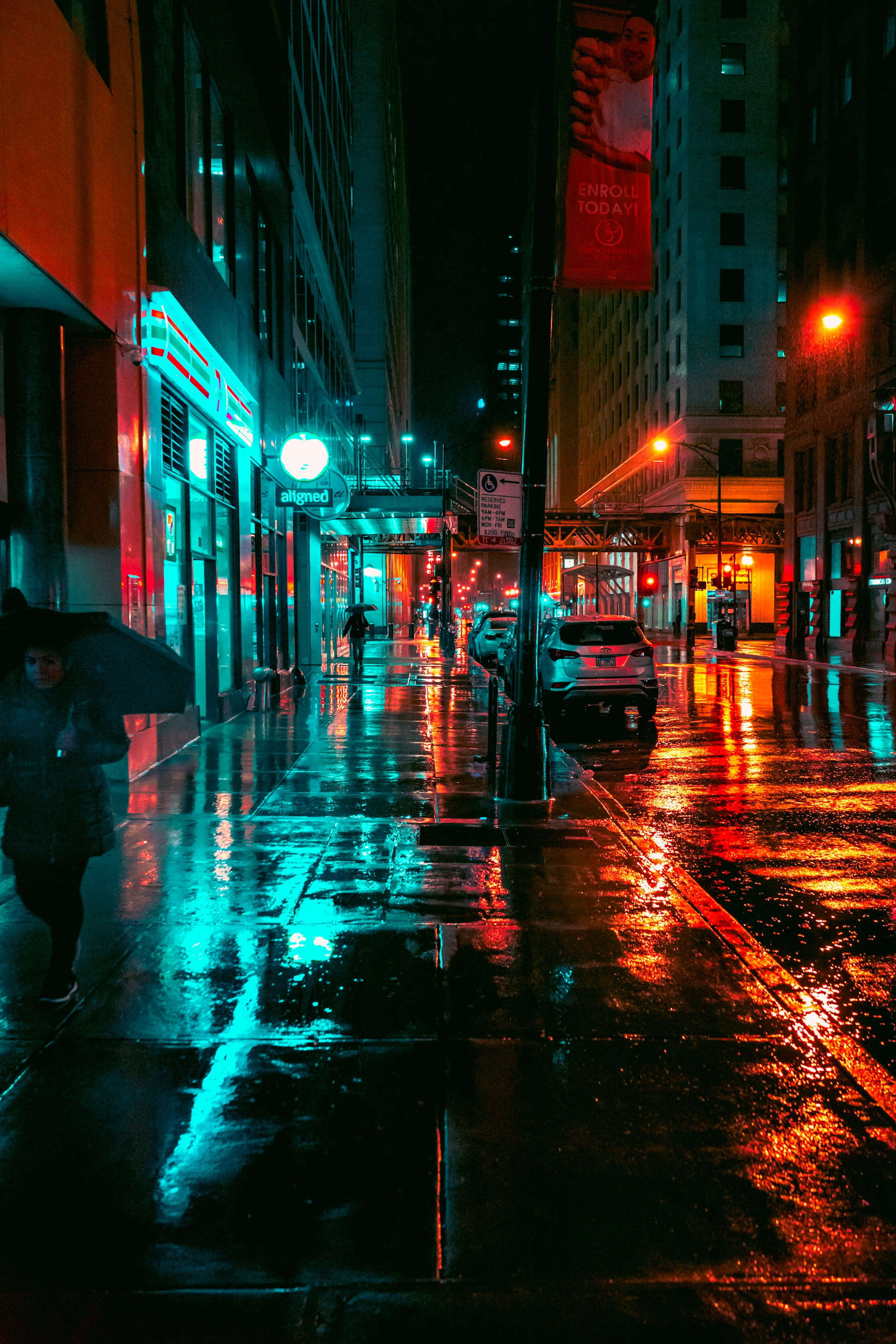 A rain-lit city street glowing with blue and amber lights